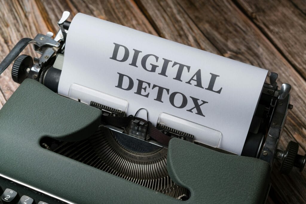 pexels-photo-18524063-18524063 An overhead view of a typewriter printing 'Digital Detox' on wooden background.