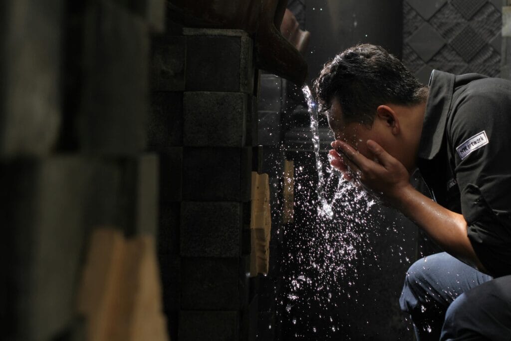 pexels-photo-984132-984132 A man washes his face with flowing water indoors, highlighting daily hygiene and refreshment.