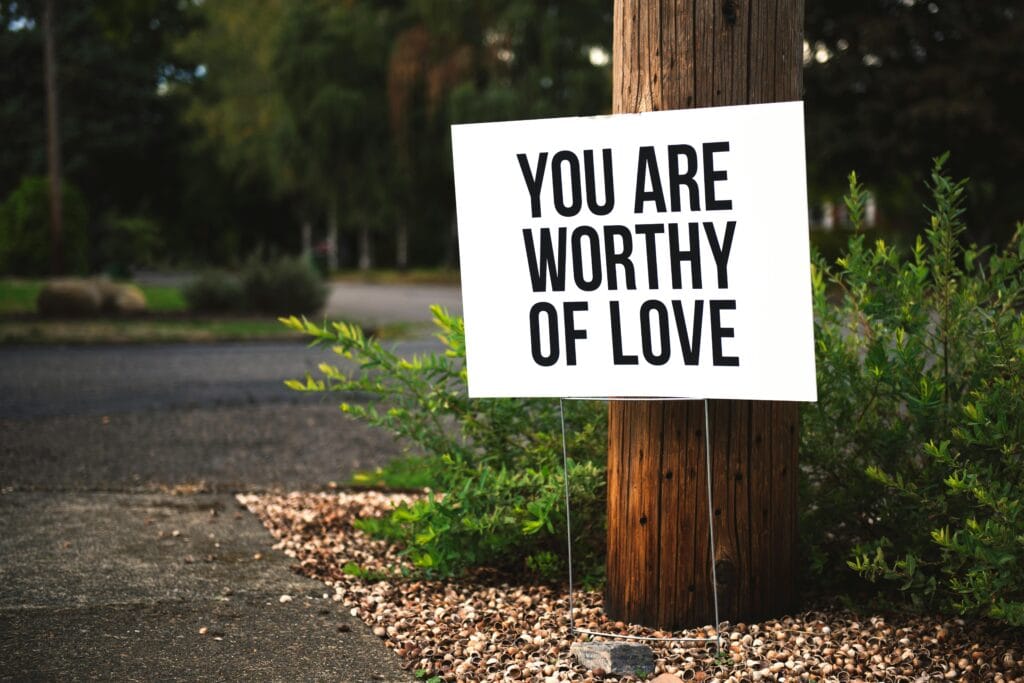 pexels-photo-953162-953162 A positive message sign "You are worthy of love" in a park setting.